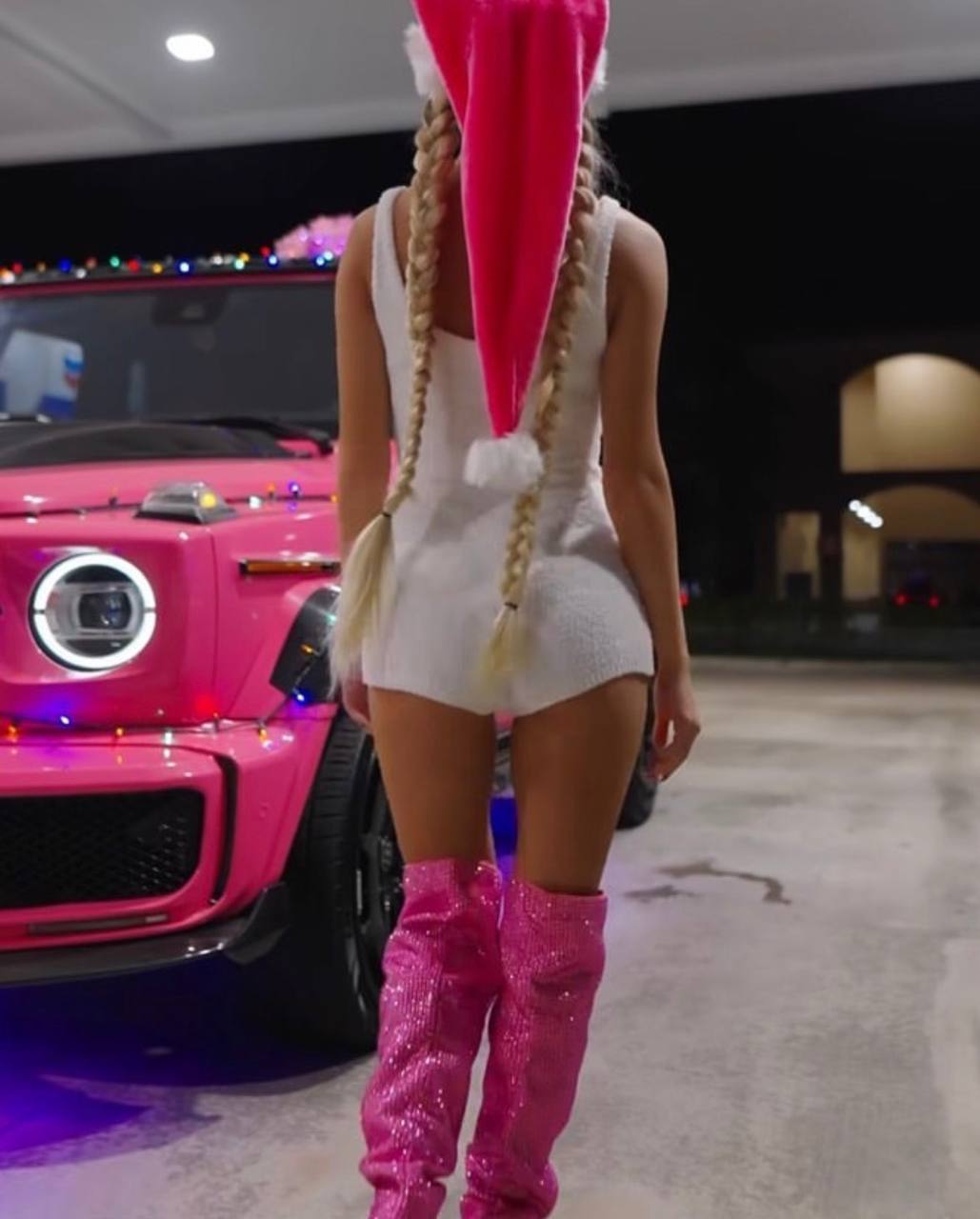 Pose nocturne devant une voiture rose décorée de guirlandes lumineuses